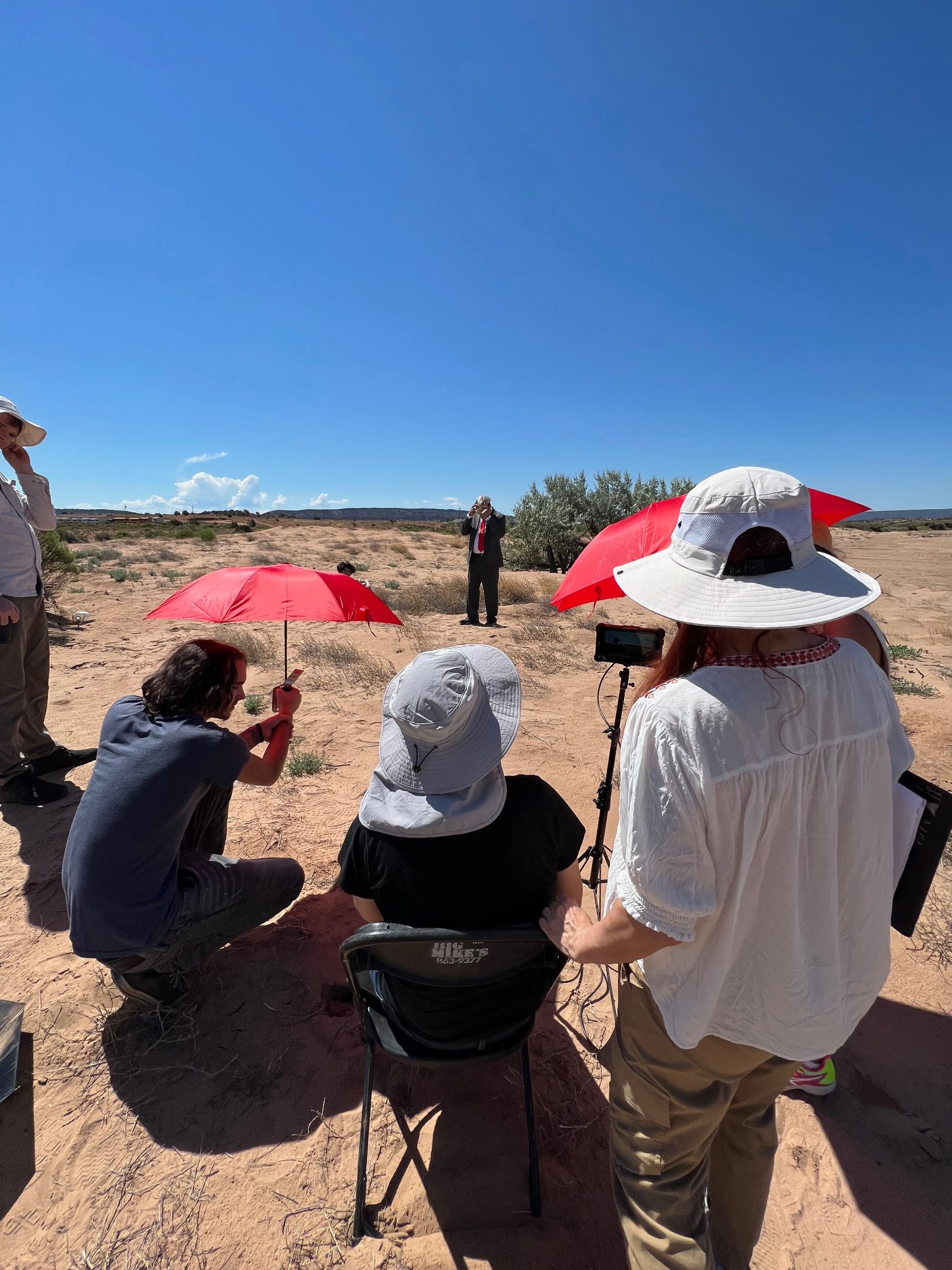 Crew filming in the desert — red umbrellas, Navajo Nation